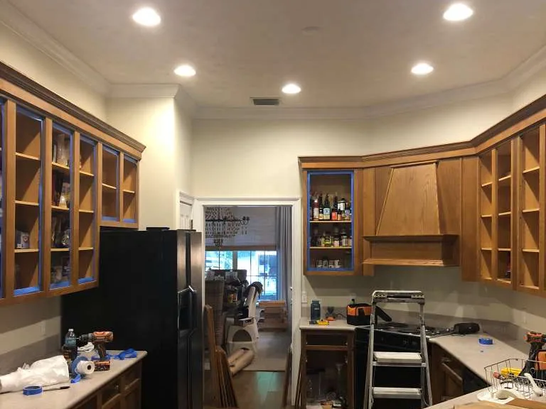 Kitchen cabinets before, in a dark wood stain with work underway