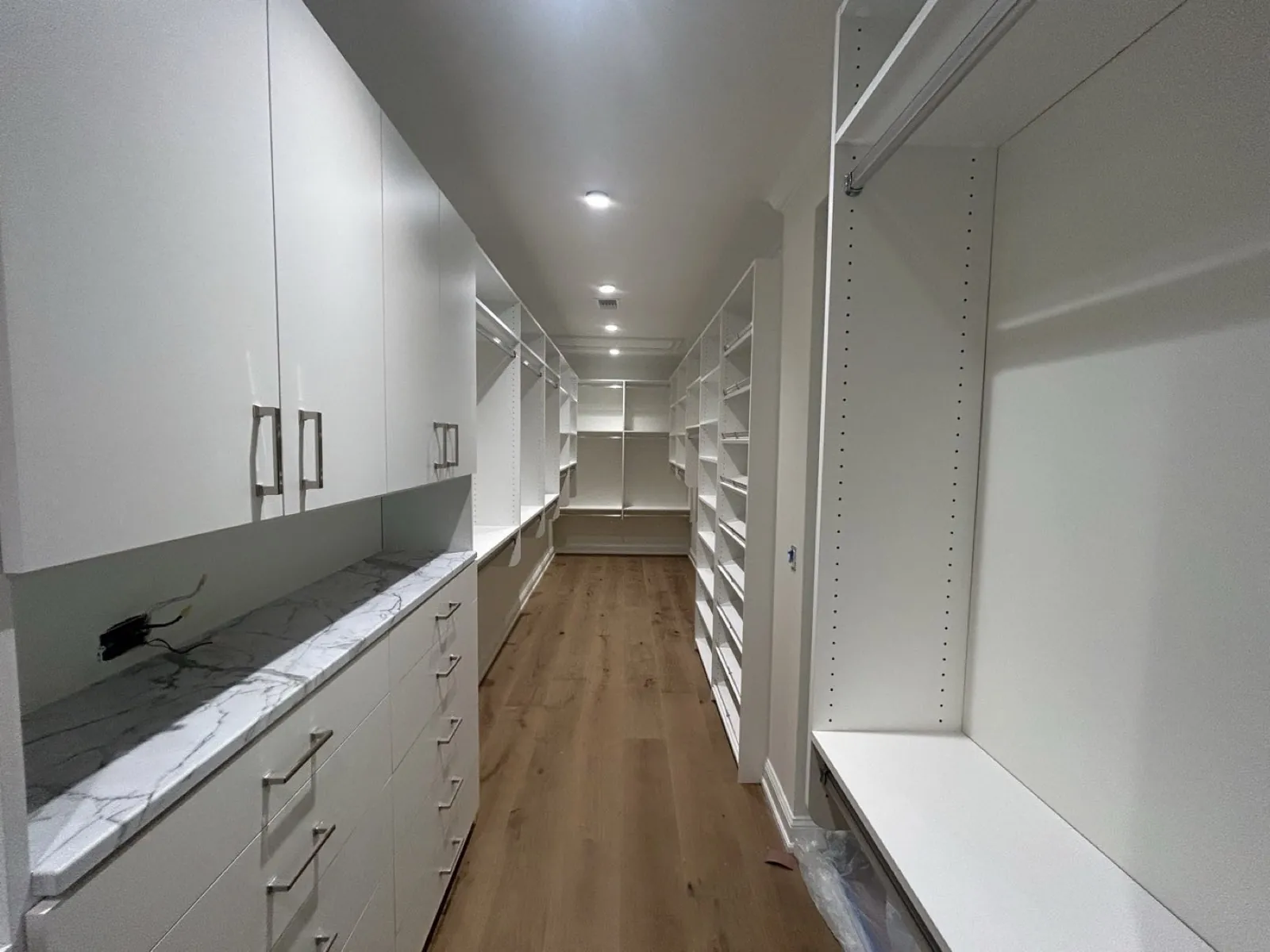 White built-in cabinets and shelving with a marble countertop