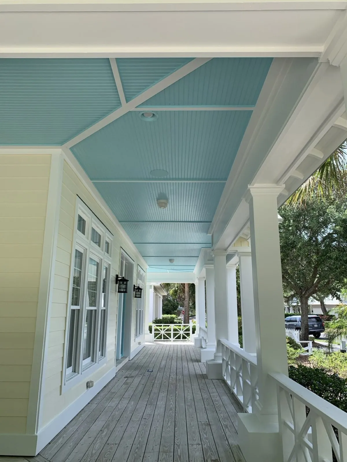 Covered porch with a haint blue ceiling and white railings